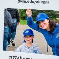 Alumna and little Laker pose with #GVhomecoming sign